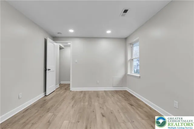 a view of hallway with a window and wooden floor