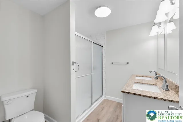 a bathroom with a granite countertop sink toilet and shower