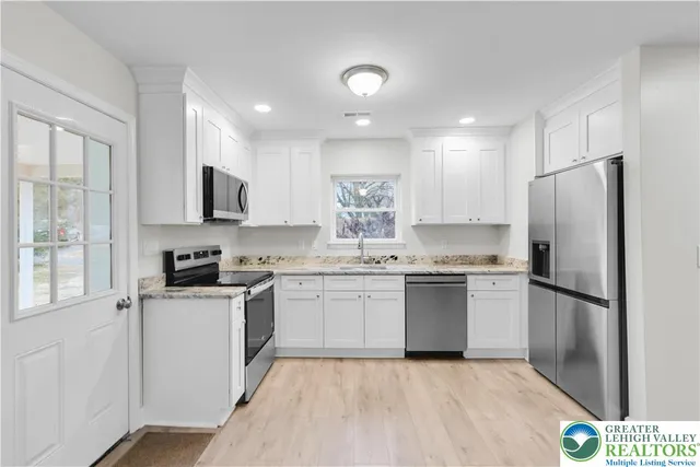 a kitchen with a refrigerator a sink and a stove top oven