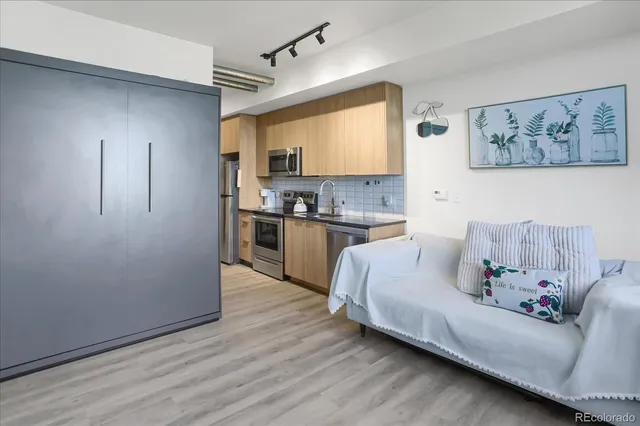 a kitchen with stainless steel appliances granite countertop white cabinets a refrigerator and a sink