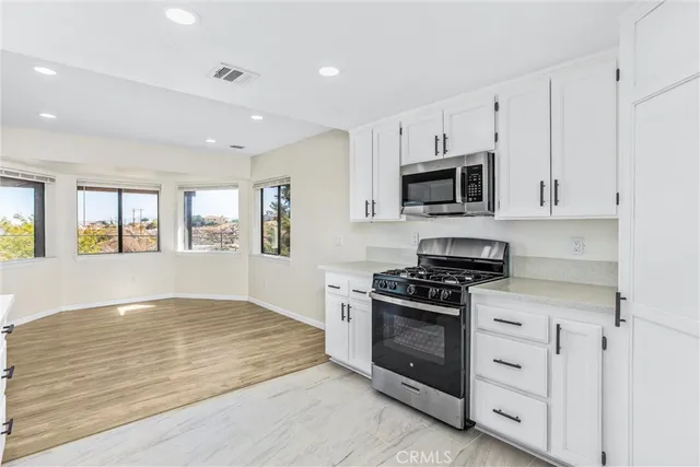 an empty room with wooden floor closet and fan