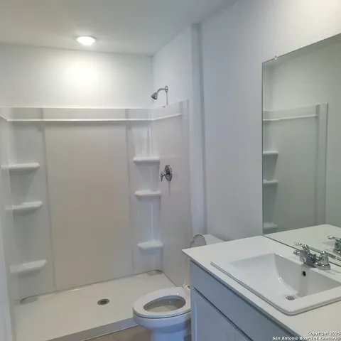 a bathroom with a sink a toilet and shower