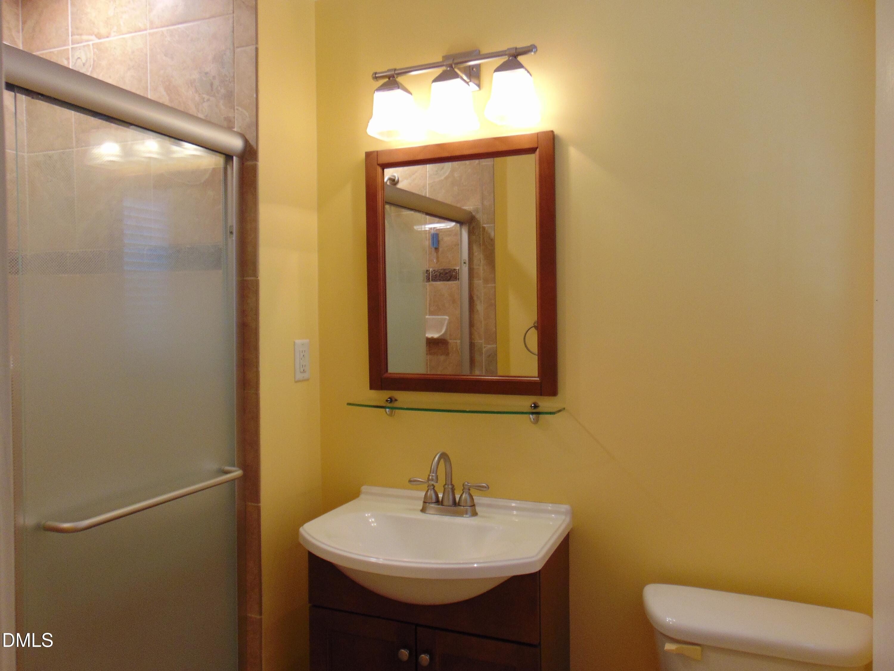 442 Gus Road Durham, NC 27703 - Photo 43 of 56 a bathroom with a toilet sink and mirror