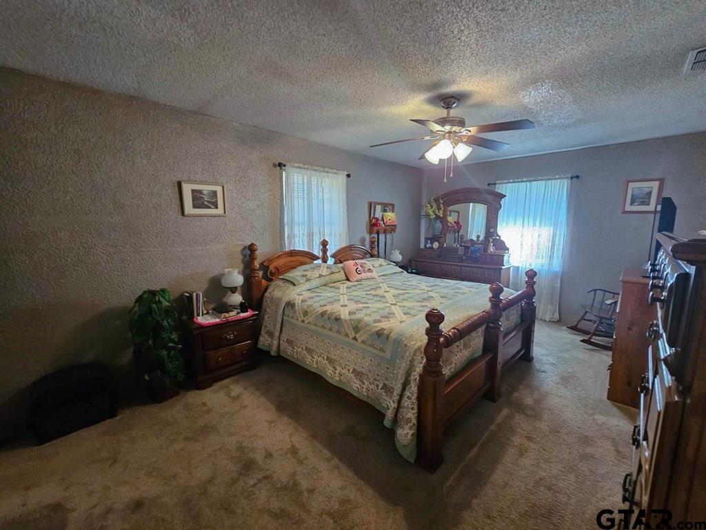 517 An County Road Palestine, TX 75801 - Photo 24 of 41 a bedroom with a bed and a chandelier