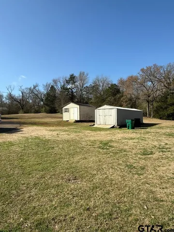 a view of a yard with a house in the background