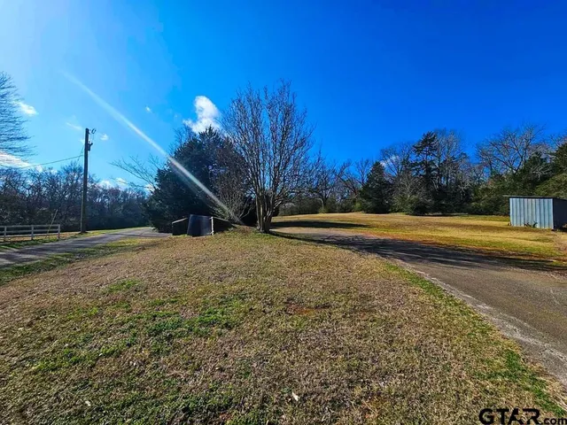 a view of a yard with wooden fence