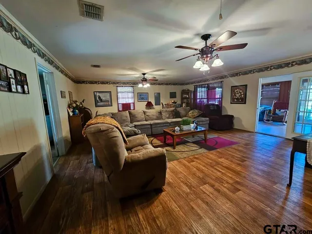 a living room with furniture and a wooden floor