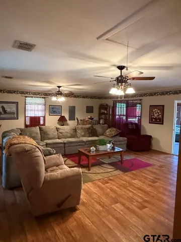 a living room with furniture kitchen view and a flat screen tv