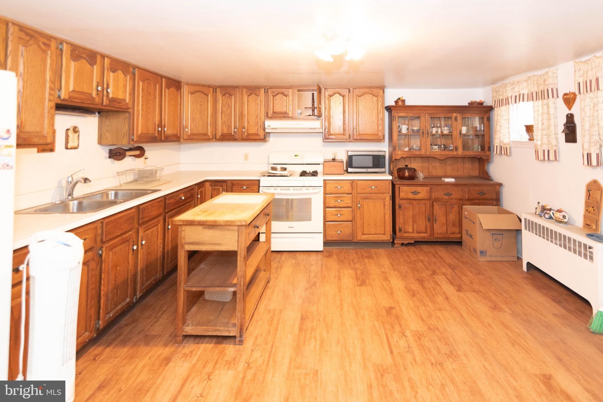 3040 Federal Street Baltimore, MD 21213 - Photo 21 of 38 a kitchen with wooden floors and wooden cabinets