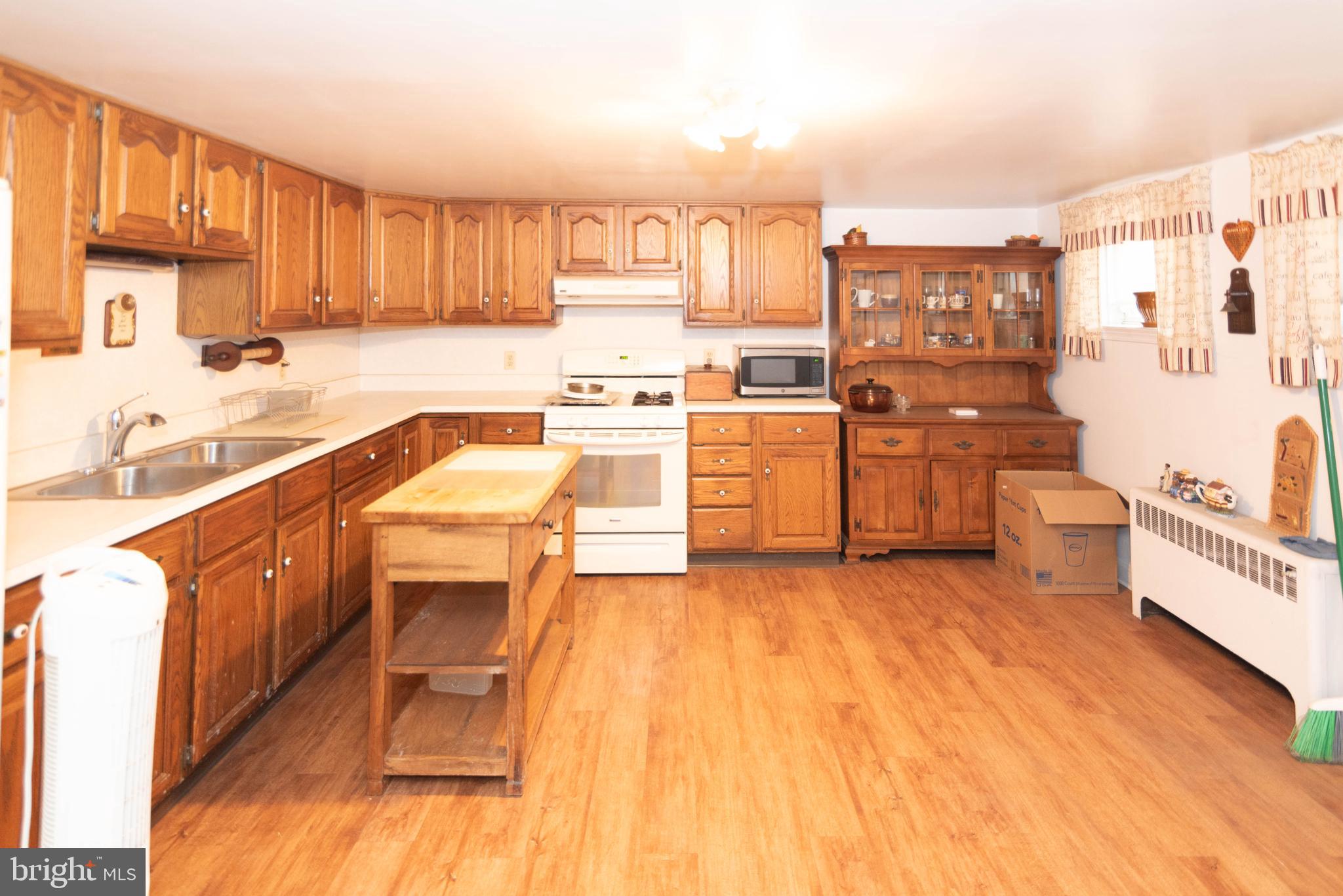 3040 Federal Street Baltimore, MD 21213 - Photo 23 of 38 a kitchen with stainless steel appliances granite countertop a stove a sink dishwasher and a refrigerator with wooden cabinets
