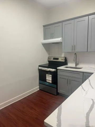 a kitchen with a sink cabinets and wooden floor