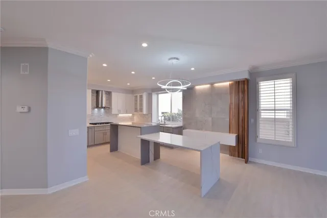 a view of a hallway with stainless steel appliances granite countertop a refrigerator and a sink