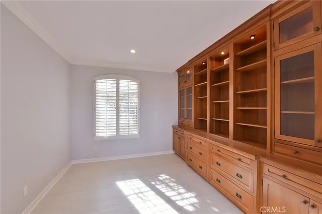 a view of an empty room with furniture and window