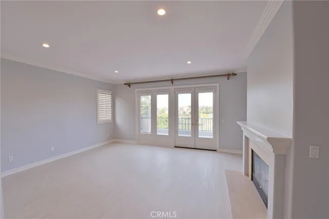 a view of a white house with a yard plants and large tree