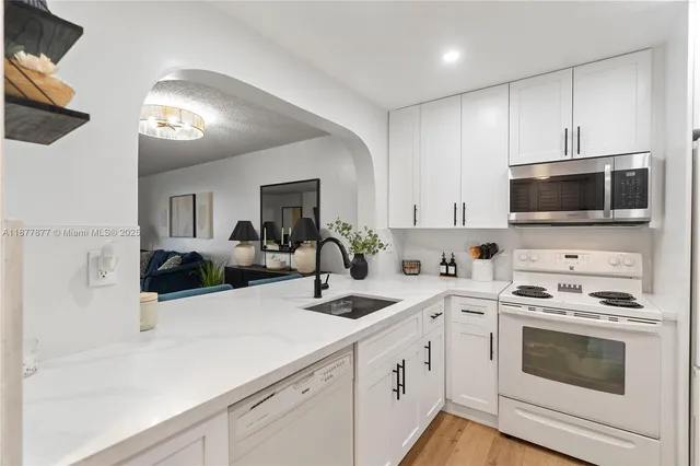 a kitchen with a sink a stove and microwave