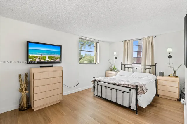 a bedroom with a bed and a flat tv screen on the dresser