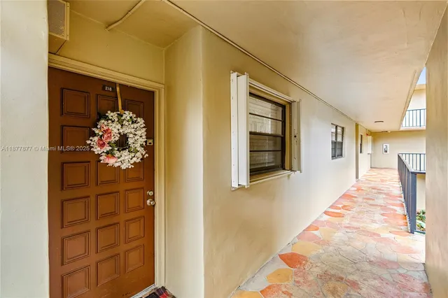 a view of a hallway with wooden floor and a potted plant
