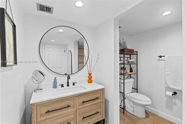 a bathroom with a sink toilet and a mirror