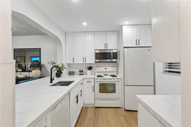 a kitchen with a sink a stove a refrigerator and cabinets