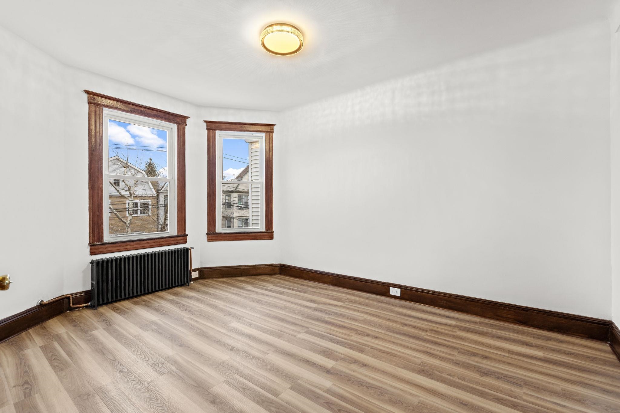 379 Union Street, Unit 2 Jersey City, NJ 07304 - Photo 16 of 20 a view of an empty room with a window and wooden floor