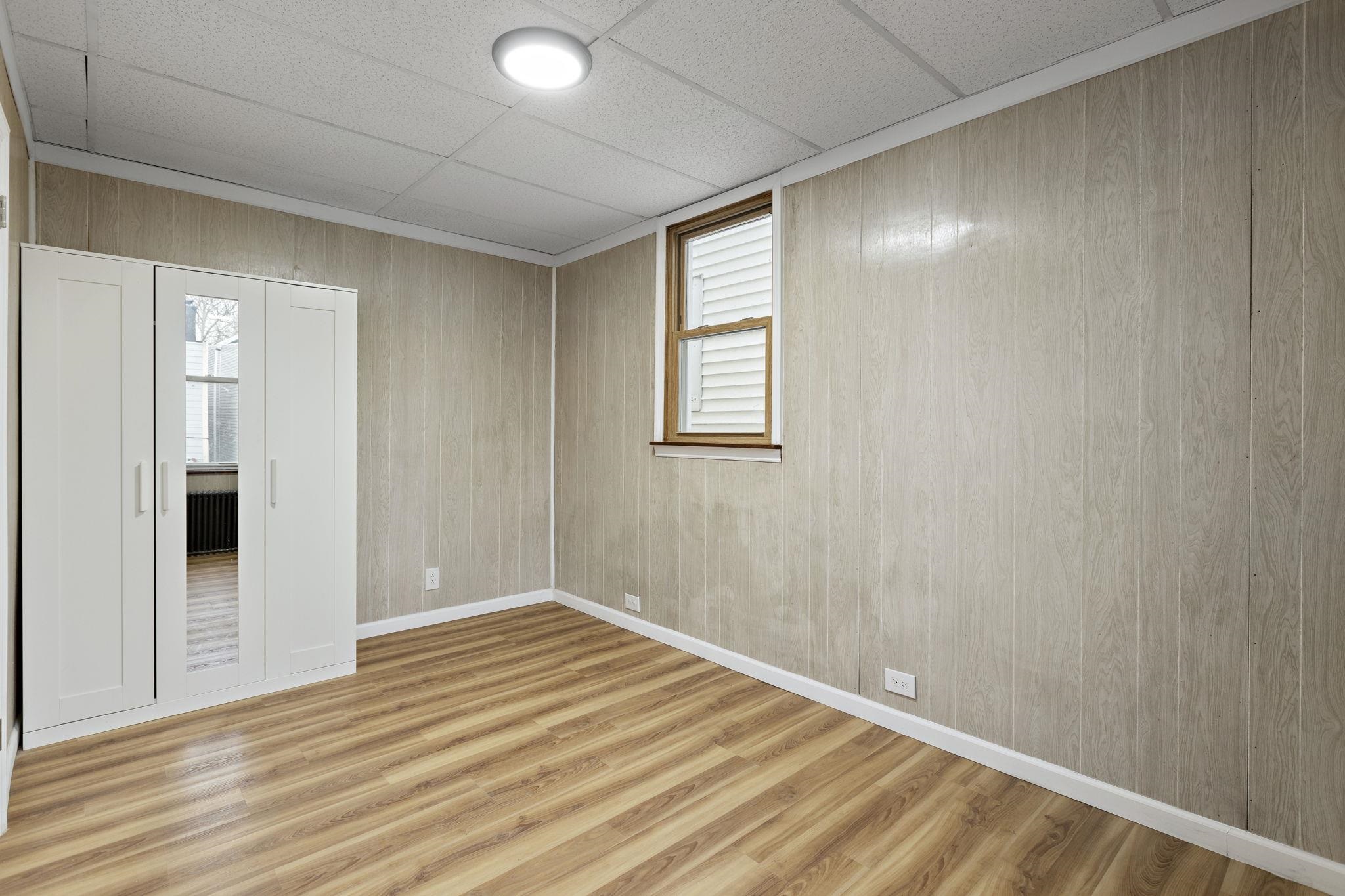379 Union Street, Unit 2 Jersey City, NJ 07304 - Photo 3 of 20 a view of an empty room with wooden floor and a window