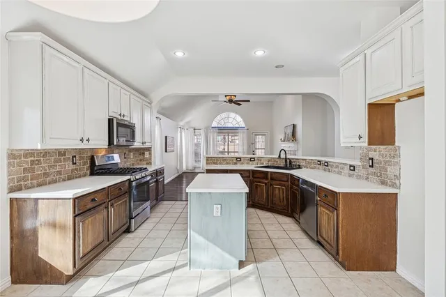 a kitchen with granite countertop white cabinets and stainless steel appliances