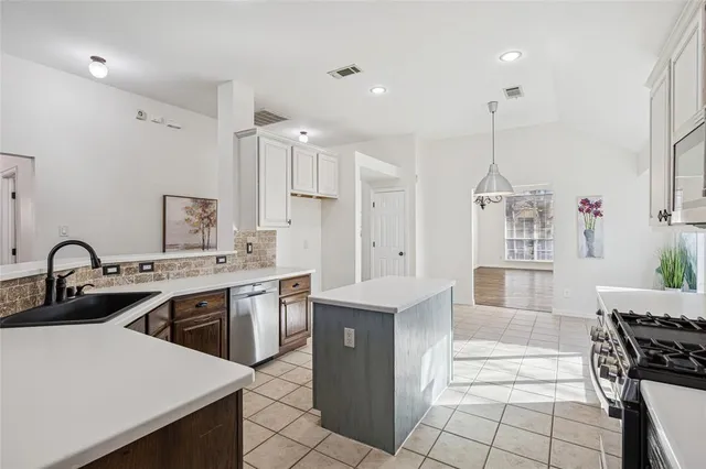a kitchen with a stove a sink and a counter top space
