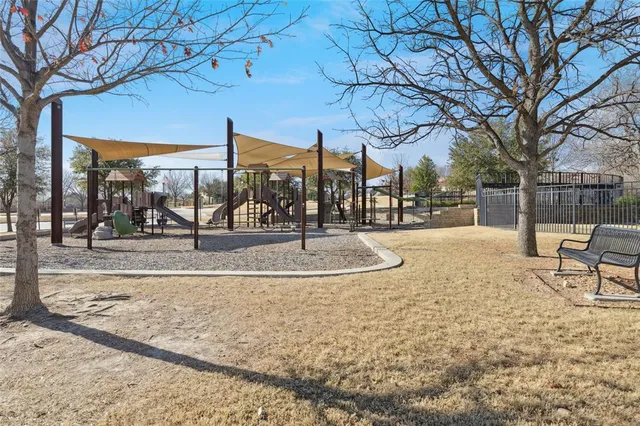 a view of swimming pool with seating area and trees in the background
