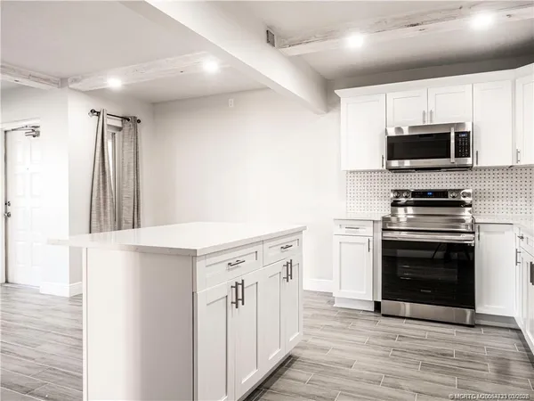 a kitchen with stainless steel appliances a stove microwave and a refrigerator
