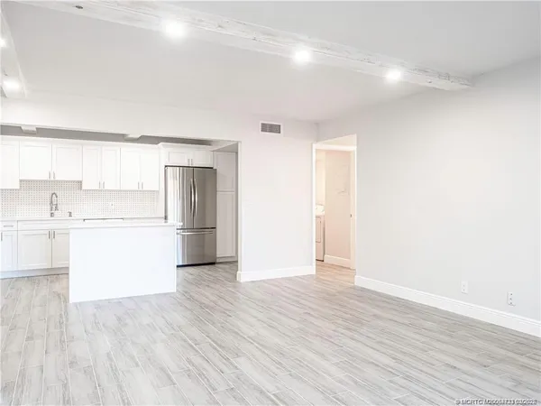 a view of a kitchen with a sink and a refrigerator