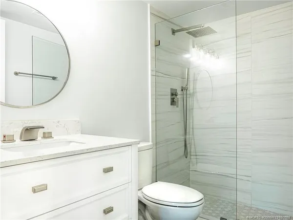 a bathroom with a sink a toilet and shower