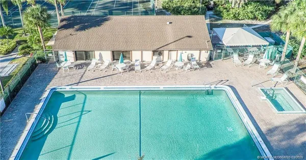 a backyard of a house with table and chairs under an umbrella