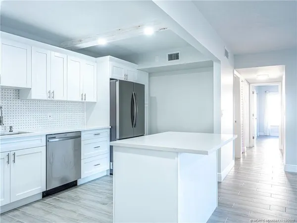 a kitchen with stainless steel appliances a refrigerator and wooden cabinets