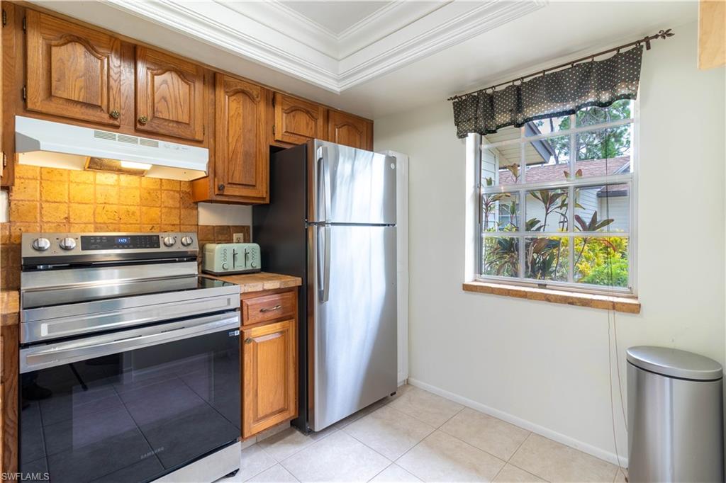 1014 Pine Isle Lane, Unit 1014 Naples, FL 34112 - Photo 5 of 20 a kitchen with stainless steel appliances a refrigerator and a window