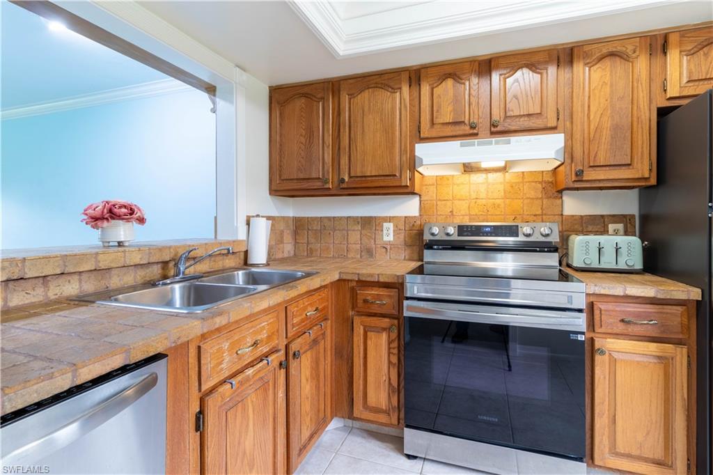 1014 Pine Isle Lane, Unit 1014 Naples, FL 34112 - Photo 6 of 20 a kitchen with granite countertop a sink stainless steel appliances and cabinets