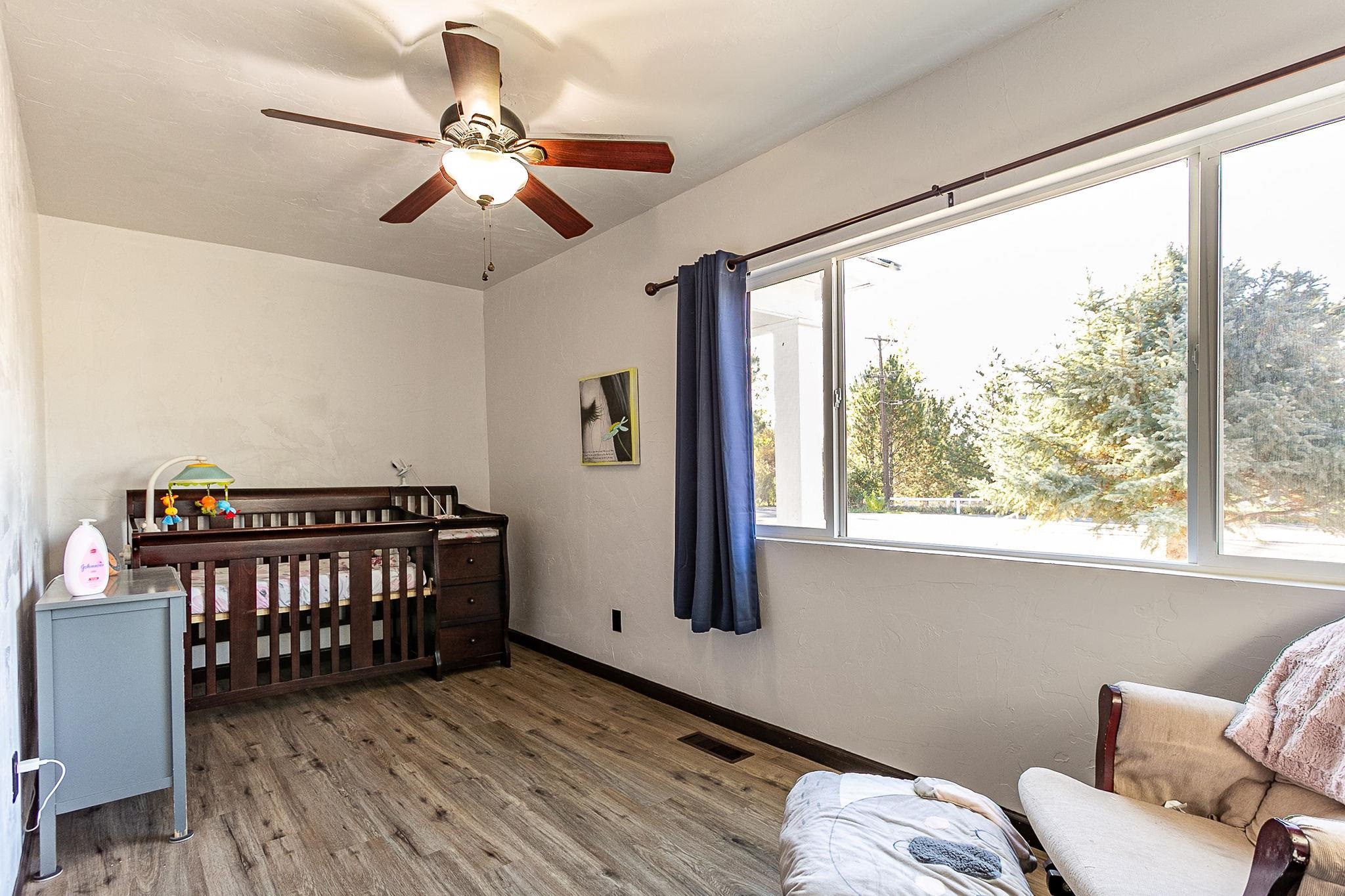 3612 G Road Palisade, CO 81526 - Photo 19 of 38 a bedroom with furniture window and wooden floor