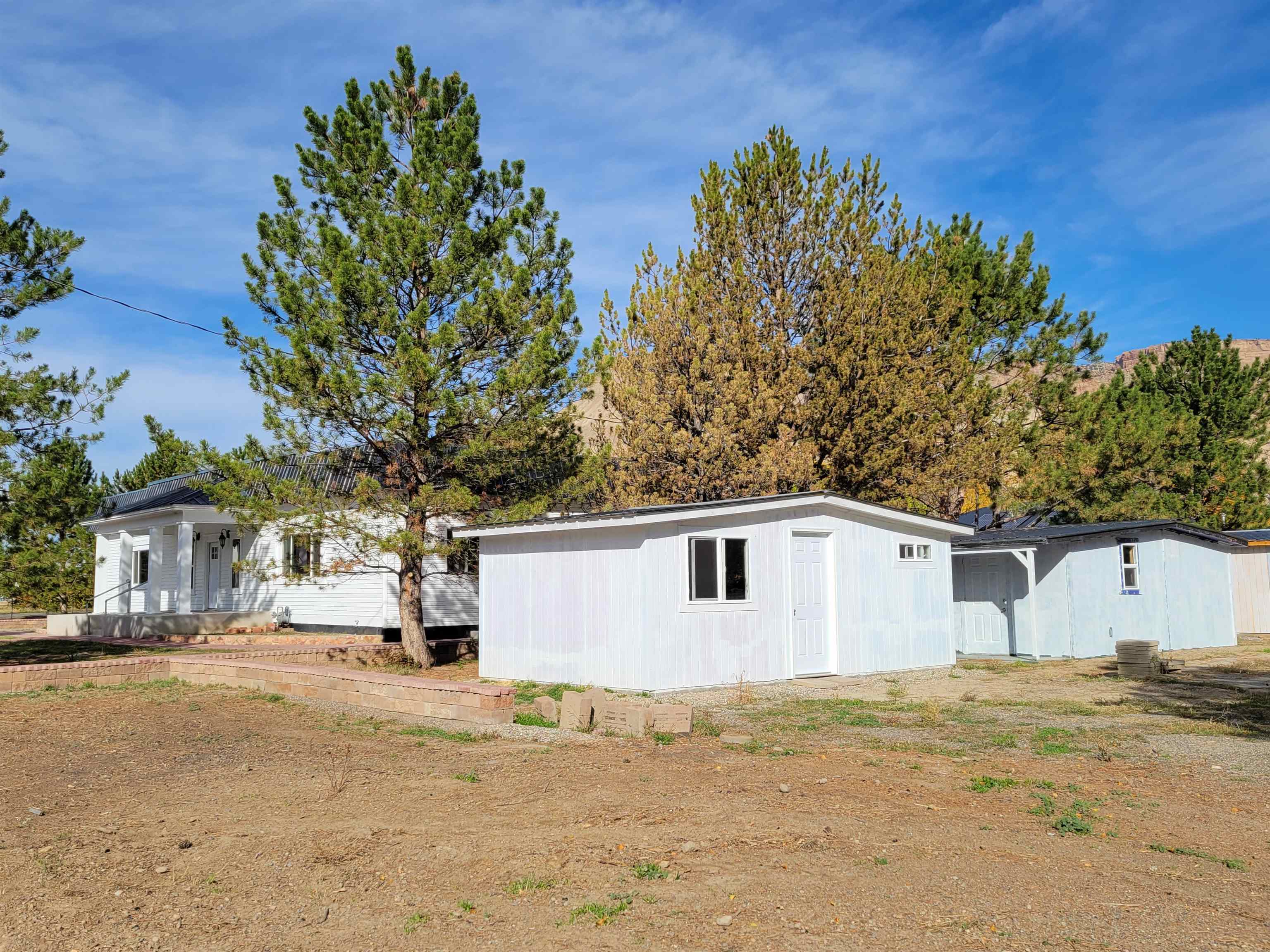 3612 G Road Palisade, CO 81526 - Photo 34 of 38 a view of a white house with a yard and large tree