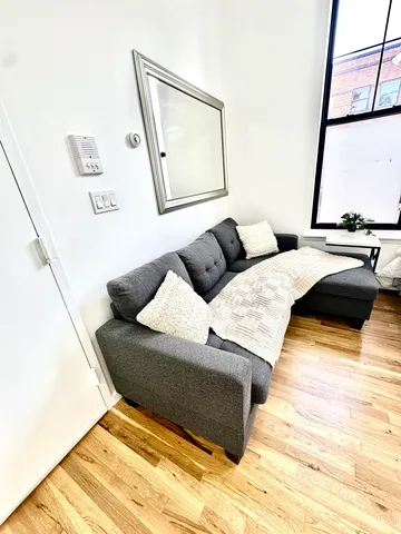 a living room with a bed and a window
