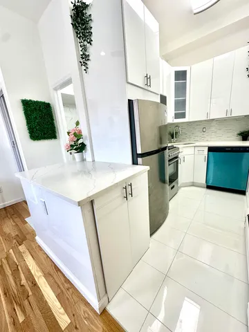 a kitchen with white cabinets and sink
