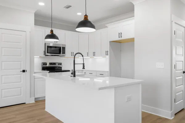 a kitchen with stainless steel appliances a stove a sink and a microwave