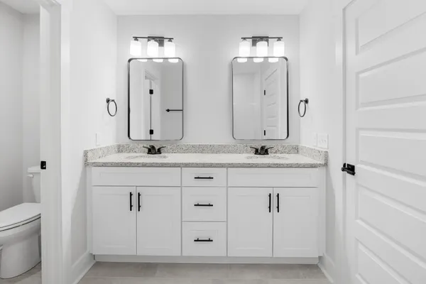 a bathroom with double sink and a mirror