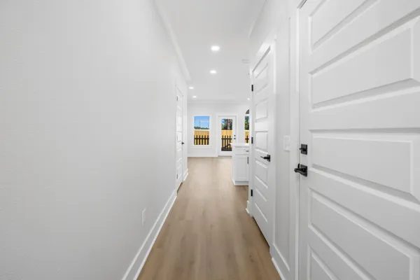 a view of a hallway with wooden floor and staircase