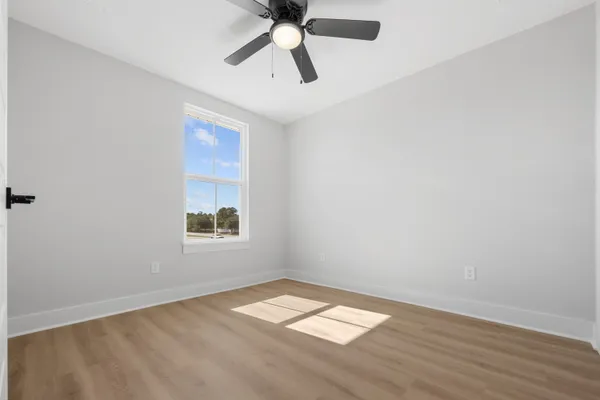 an empty room with a window and a fan