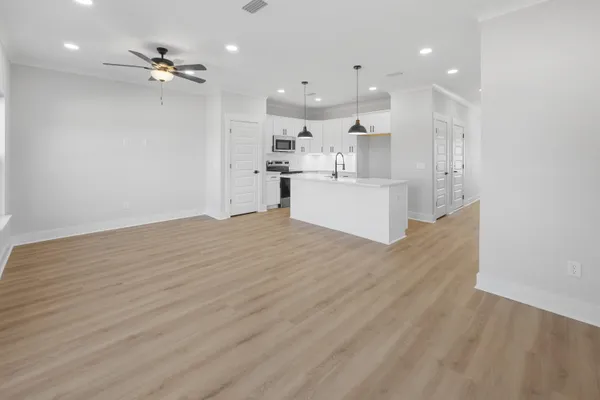 a view of kitchen with kitchen island white cabinets and stainless steel appliances
