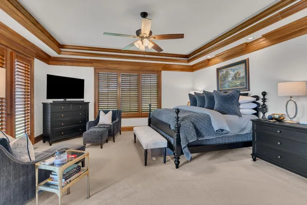 a bedroom with furniture a flat screen tv and a window