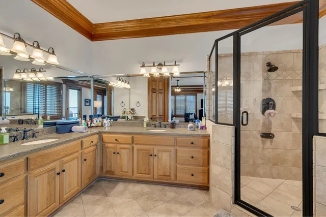 a large bathroom with a double vanity sink a toilet a shower and a mirror