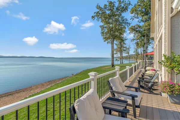 a view of a chairs and table in patio with a lake view