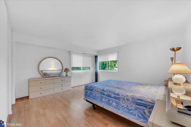 a bedroom with a bed and a dresser with mirror