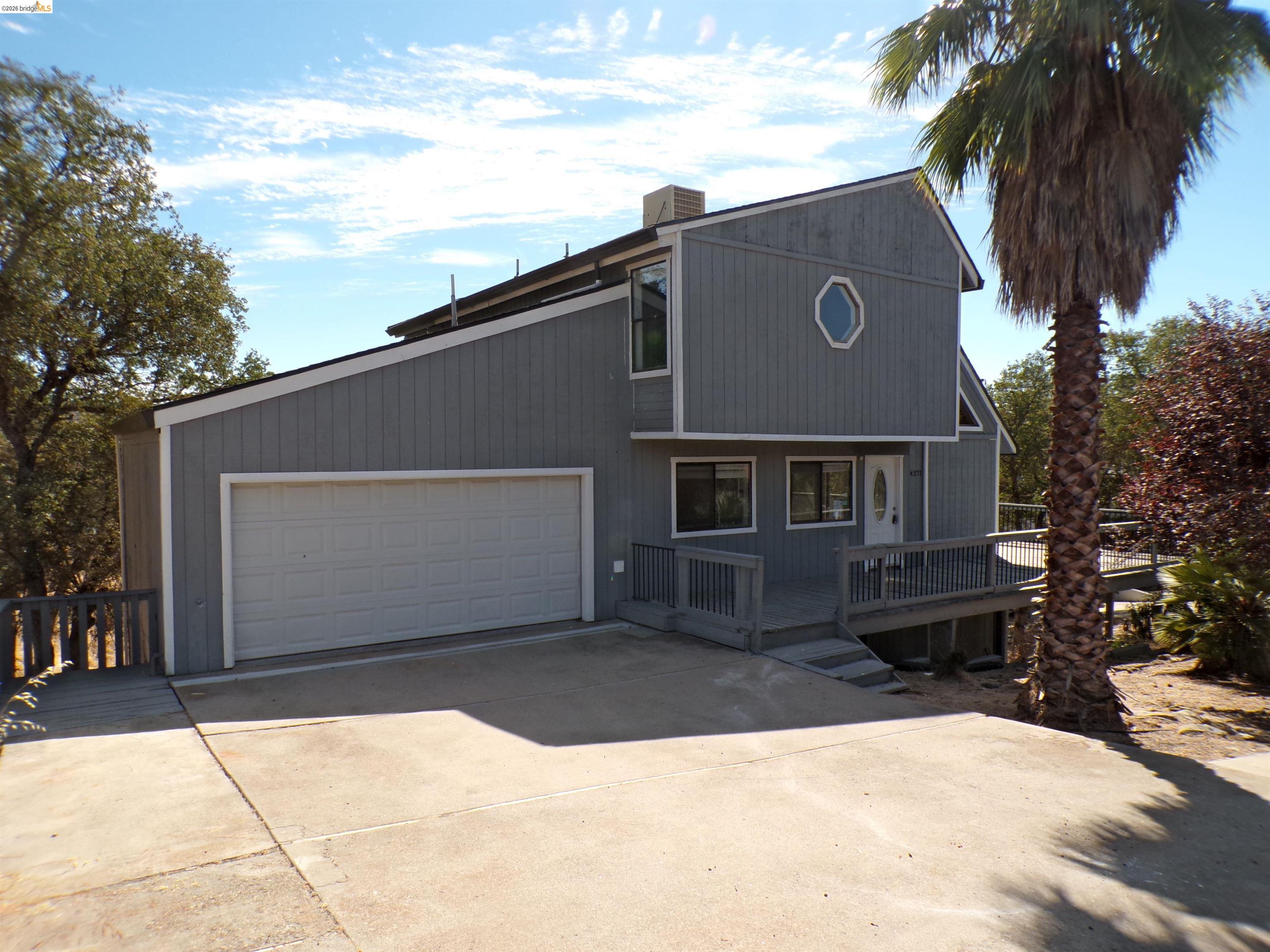 Multi-level residence featuring gray vertical siding and white trim