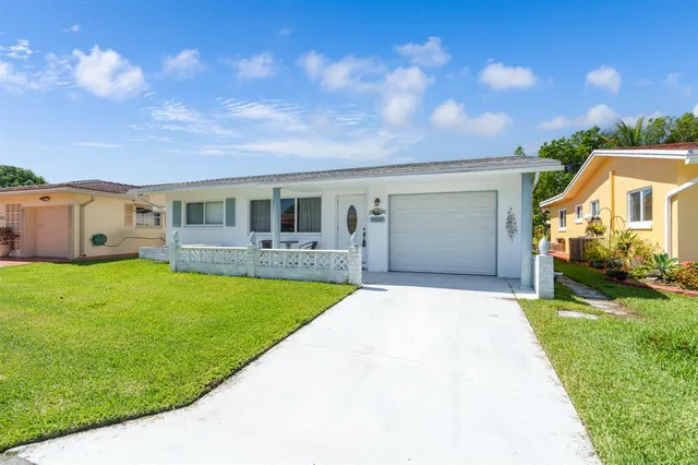 a front view of a house with a garden and yard